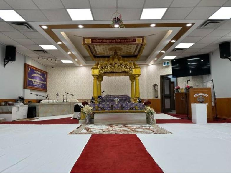 Inside the Darbar Hall at Dashmesh Darbar, with the red carpet leading to the front